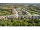 Wide aerial view of a neatly planned community with well-spaced homes, mature trees, and recreational areas at 228 Caserta Ct, North Venice, FL 34275