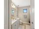 Bright bathroom featuring double sinks, tile floors, and a shower with natural light at 228 Caserta Ct, North Venice, FL 34275