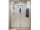 Modern bathroom shower with a glass door, white tile, and window for natural light at 228 Caserta Ct, North Venice, FL 34275