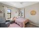Charming bedroom featuring a ceiling fan and bright windows, and a cozy pink color scheme at 228 Caserta Ct, North Venice, FL 34275