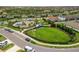 Aerial view of a beautiful community park with playground, green spaces, and walking paths in a residential neighborhood at 228 Caserta Ct, North Venice, FL 34275