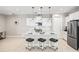Bright, open kitchen with white cabinetry, quartz counters, stainless appliances and eat-in island with barstool seating at 228 Caserta Ct, North Venice, FL 34275