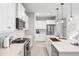 Modern kitchen featuring white cabinets, stainless appliances, and quartz countertops at 228 Caserta Ct, Nokomis, FL 34275