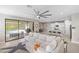 Open-concept space with large sectional couch, view to the kitchen and to the outdoor pool area through sliding glass doors at 228 Caserta Ct, North Venice, FL 34275