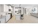 Open concept living space with bright white kitchen, eat-in island, stainless appliances, tile flooring and comfortable living area at 228 Caserta Ct, North Venice, FL 34275