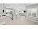 Open-concept living space with kitchen, living room, eat-in island, stainless appliances, white cabinetry, and tile flooring at 228 Caserta Ct, North Venice, FL 34275