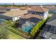 Aerial view of a pool with screened enclosure, black fence, and tropical landscaping in a well-maintained backyard at 228 Caserta Ct, North Venice, FL 34275