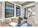Cozy covered porch with seating and a blue rug, featuring a view of the home's entrance and garage at 228 Caserta Ct, North Venice, FL 34275