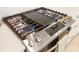 Close up of modern KitchenAid stainless steel gas stove with multiple burners and griddle at 228 Caserta Ct, North Venice, FL 34275