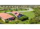 Aerial shot of homes featuring a pool, solar panels, lush greenery, and well-manicured lawn at 24036 Spartina Dr, Venice, FL 34293