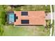 Overhead view of home showing pool, solar panels, tile roof, well-manicured lawn, and lush greenery at 24036 Spartina Dr, Venice, FL 34293