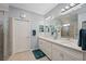 Spacious primary bathroom features dual sink vanity, neutral colors, and walk-in shower with decorative door at 24036 Spartina Dr, Venice, FL 34293