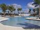 Spacious community pool, lined with palm trees and lounge chairs, perfect for relaxation at 24036 Spartina Dr, Venice, FL 34293