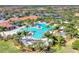 Aerial view of the resort-style community pool, surrounded by palm trees, and clubhouse at 24036 Spartina Dr, Venice, FL 34293