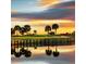 Scenic golf course view at sunset, featuring water features and palm trees at 24036 Spartina Dr, Venice, FL 34293