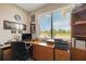 The home office offers an outside view, wood desk, and neutral walls, providing a tranquil workspace at 24036 Spartina Dr, Venice, FL 34293