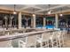 Enjoy the poolside bar overlooking the sparkling pool, palm trees, and comfortable seating area at 24036 Spartina Dr, Venice, FL 34293