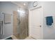 Detailed shot of the glass enclosed shower with decorative door and neutral tiled walls in the primary bathroom at 24036 Spartina Dr, Venice, FL 34293
