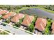 An aerial view of homes with tile roofs along the water in a landscaped community at 24044 Canterwood Way, Venice, FL 34293