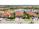 Aerial view of homes with tile roofs, landscaping, and pond at 24044 Canterwood Way, Venice, FL 34293