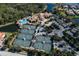 Aerial view showcasing the tennis courts, pool, landscaping, and parking area at 246 Montelluna Dr, North Venice, FL 34275