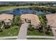 Aerial view of single-story home with paver driveway, lush landscaping, and stunning lake view at 246 Montelluna Dr, North Venice, FL 34275