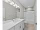 Well-appointed bathroom with a combination tub and shower, bright lighting, and a sleek white vanity at 27440 Janzen Ct, Englewood, FL 34223