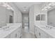 Bathroom with double vanity, mirrors and an entrance to shower at 27440 Janzen Ct, Englewood, FL 34223