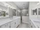 Bright bathroom with double vanity, mirrors and glass shower at 27440 Janzen Ct, Englewood, FL 34223