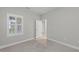 Inviting bedroom with plush carpeting, bright window, and a doorway to a hallway at 27440 Janzen Ct, Englewood, FL 34223