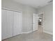 Well-lit bedroom with a view to the kitchen, tiled floors and double door closet at 27440 Janzen Ct, Englewood, FL 34223