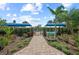 Welcoming entrance to Club Belize with lush landscaping and inviting walkway at 27440 Janzen Ct, Englewood, FL 34223