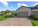 Brick paved driveway leading to a home with well-manicured landscaping at 27440 Janzen Ct, Englewood, FL 34223