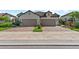 Inviting two-story home featuring a brick driveway, tan exterior, and two-car garage at 27440 Janzen Ct, Englewood, FL 34223