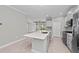 Bright, open kitchen featuring an island with stone countertops and stainless steel appliances at 27440 Janzen Ct, Englewood, FL 34223