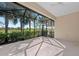 Bright and spacious screened lanai with a view of palm trees and tropical foliage at 27440 Janzen Ct, Englewood, FL 34223