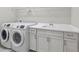 Well-equipped laundry room features modern washer, dryer, sink, and ample cabinet space at 27440 Janzen Ct, Englewood, FL 34223