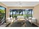 Covered patio with comfortable seating, ceiling fan, and views of lush landscaping at 27440 Janzen Ct, Englewood, FL 34223