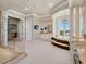 This primary bath boasts an ocean view, dual vanities, a glass shower, a soaking tub, and sleek white cabinetry at 2821 Casey Key Rd, Nokomis, FL 34275