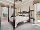 Luxurious bedroom with a four-poster bed, stylish decor, and bright natural light at 2821 Casey Key Rd, Nokomis, FL 34275