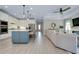 View of the kitchen and living area featuring white cabinets, stainless steel appliances, and a sectional sofa at 29260 Coral Harbour Dr, Englewood, FL 34223