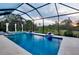 Covered pool area with integrated spa, stylish water features, and landscaped surroundings for privacy at 29260 Coral Harbour Dr, Englewood, FL 34223