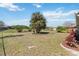 Well-maintained backyard featuring mature trees, manicured landscaping, and a sprawling green lawn at 2983 Greendale Rd, North Port, FL 34287