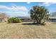 Expansive backyard showcasing lush lawn, mature palm trees, and exterior of the house at 2983 Greendale Rd, North Port, FL 34287