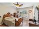 Bedroom with wood-look floors, a ceiling fan, large window, and wooden furniture at 2983 Greendale Rd, North Port, FL 34287