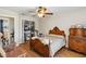 Bedroom featuring hardwood floors, an antique bed, an open closet with clothing, and a ceiling fan at 2983 Greendale Rd, North Port, FL 34287
