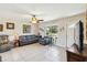 Cozy living room with tile flooring, neutral paint, ceiling fan, and comfortable seating arrangement at 2983 Greendale Rd, North Port, FL 34287
