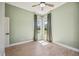 Bedroom featuring light green walls, luxury vinyl flooring, two large windows, and a modern ceiling fan at 312 Londonderry Dr, Sarasota, FL 34240