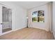 Light-filled bedroom with hardwood floors, neutral walls, a bright window, and decorative neutral-toned curtains at 312 Londonderry Dr, Sarasota, FL 34240