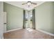 Light green bedroom featuring hardwood floors, a ceiling fan, two bright windows, and neutral walls at 312 Londonderry Dr, Sarasota, FL 34240